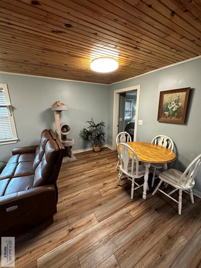 dining space with light hardwood / wood-style floors, wood ceiling, and vaulted ceiling