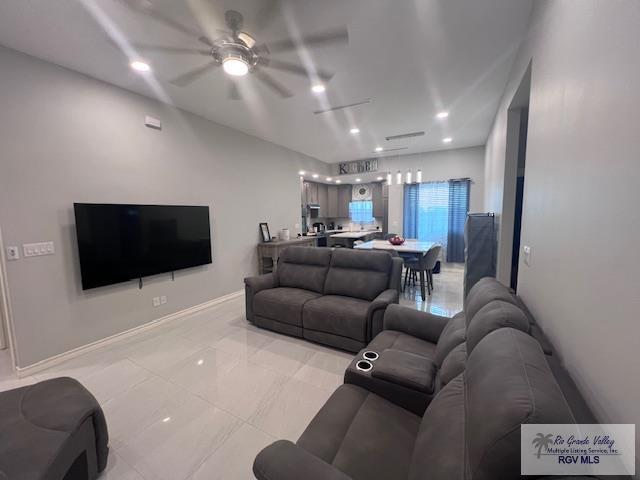 living room featuring recessed lighting, ceiling fan, and baseboards