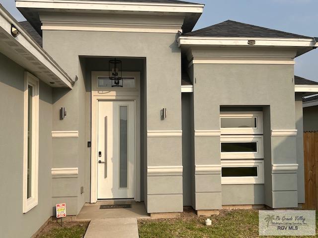 entrance to property featuring stucco siding