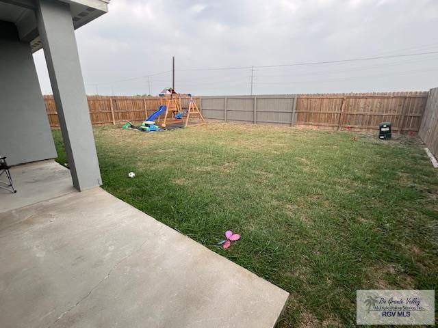 view of yard with a fenced backyard, a playground, and a patio