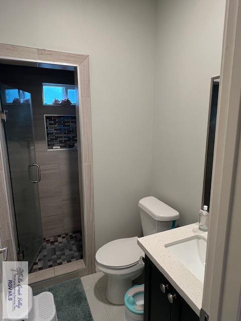 bathroom with a shower stall, toilet, and vanity