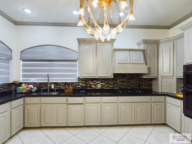 kitchen featuring backsplash, crown molding, sink, and an inviting chandelier