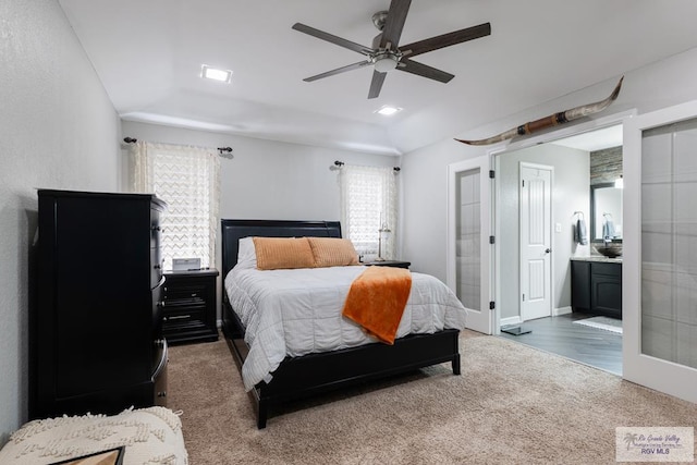 bedroom featuring ensuite bath, ceiling fan, vaulted ceiling, french doors, and dark carpet