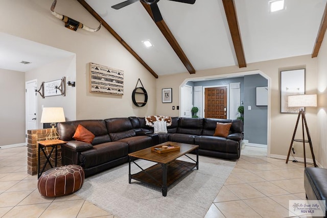 living area with baseboards, arched walkways, beamed ceiling, and light tile patterned flooring