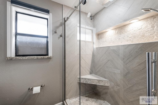 full bathroom featuring a stall shower and a textured wall