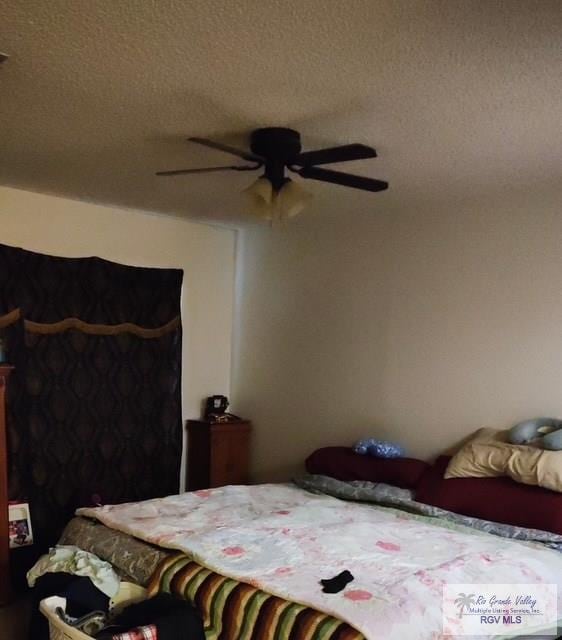 bedroom featuring a ceiling fan and a textured ceiling