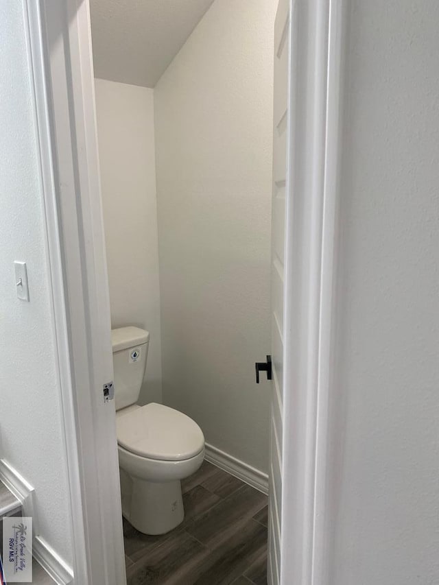 bathroom with hardwood / wood-style floors and toilet