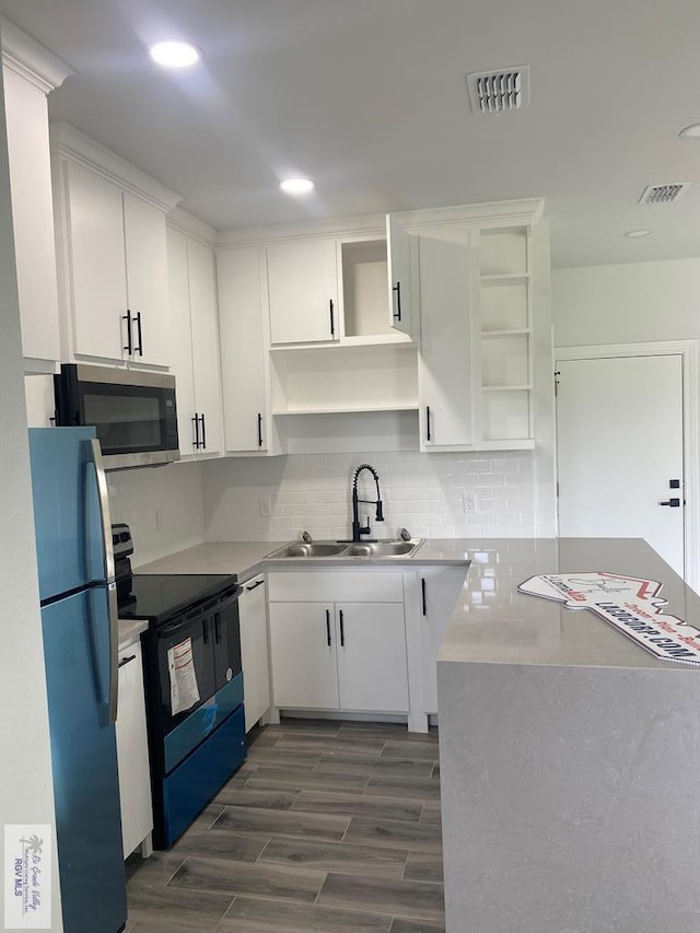 kitchen featuring dark hardwood / wood-style flooring, sink, white cabinets, and appliances with stainless steel finishes