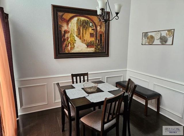 dining space with dark hardwood / wood-style floors and a notable chandelier