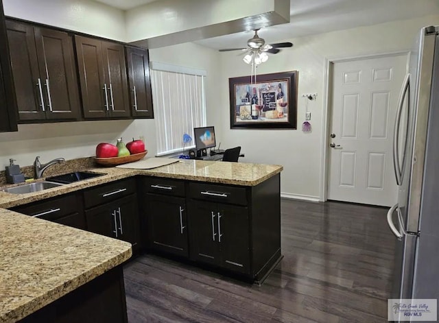 kitchen with stainless steel refrigerator, ceiling fan, sink, dark wood-type flooring, and kitchen peninsula