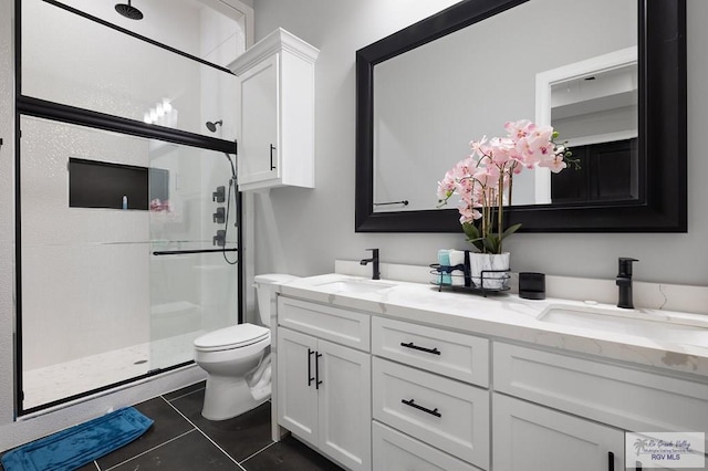 bathroom featuring tile patterned flooring, vanity, toilet, and a shower with door