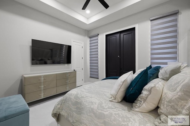 bedroom featuring ceiling fan and a tray ceiling