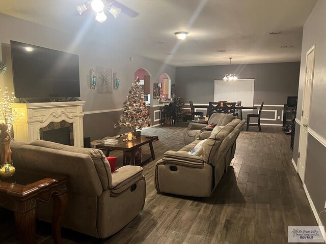 17211 Tangelo Ave, Harlingen, TX 78552 - living room featuring dark wood-type flooring, a fireplace, arched walkways, and ceiling fan