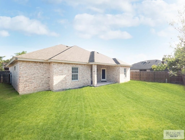 rear view of house with a yard and a patio