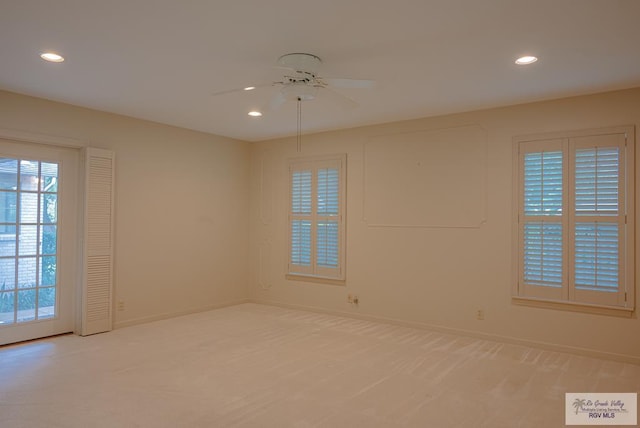 unfurnished room with ceiling fan and light carpet