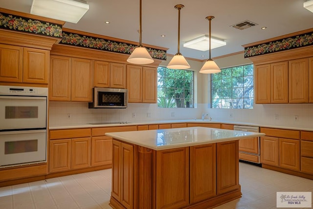 kitchen featuring black electric stovetop, decorative light fixtures, dishwasher, double oven, and a center island