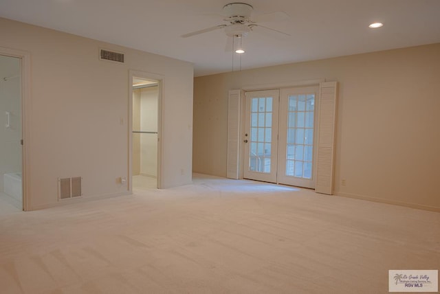 spare room featuring ceiling fan and light carpet