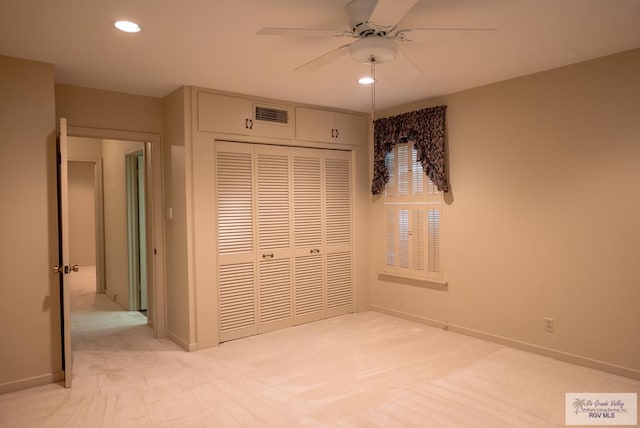 unfurnished bedroom featuring ceiling fan, a closet, and light carpet