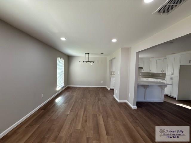 interior space featuring recessed lighting, visible vents, baseboards, dark wood-style floors, and an inviting chandelier