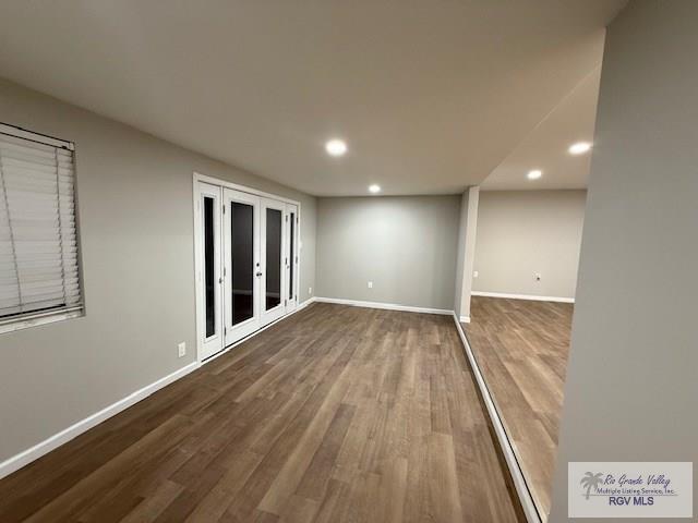 empty room with baseboards, french doors, wood finished floors, and recessed lighting