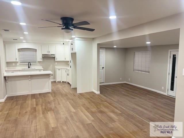 kitchen featuring light wood-type flooring, white cabinets, light countertops, and visible vents