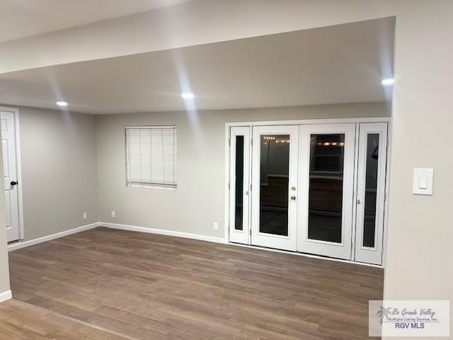 spare room featuring french doors, recessed lighting, wood finished floors, and baseboards