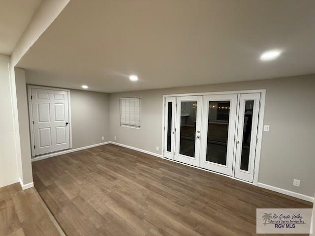 empty room with recessed lighting, french doors, dark wood finished floors, and baseboards