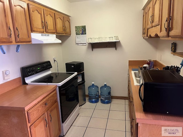 12 Palmetto Ct, Brownsville, TX 78521 - kitchen featuring electric stove, under cabinet range hood, black microwave, brown cabinets, and light tile patterned floors