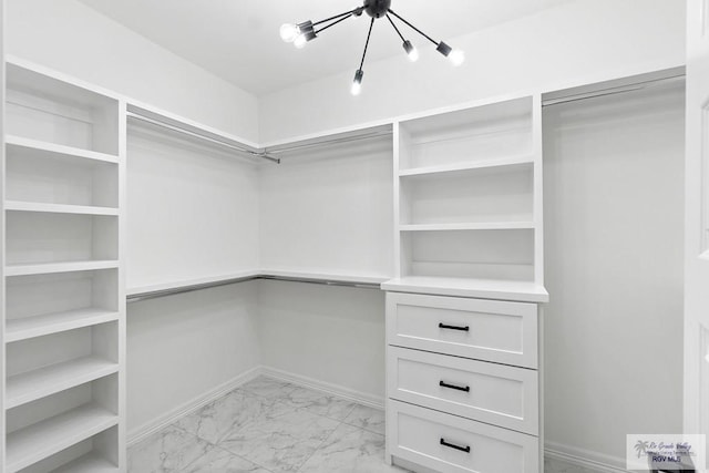 walk in closet with an inviting chandelier