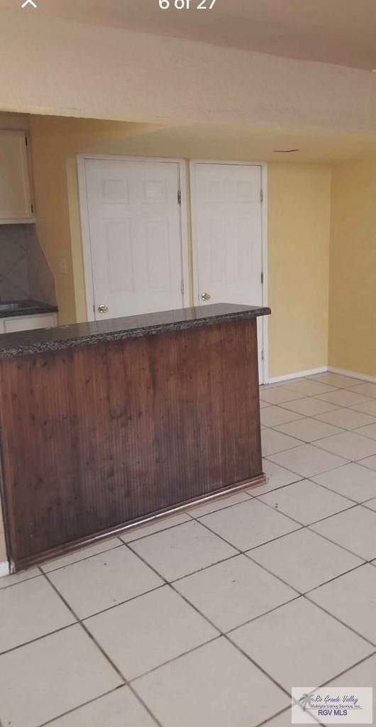 kitchen with dark countertops, baseboards, and light tile patterned floors