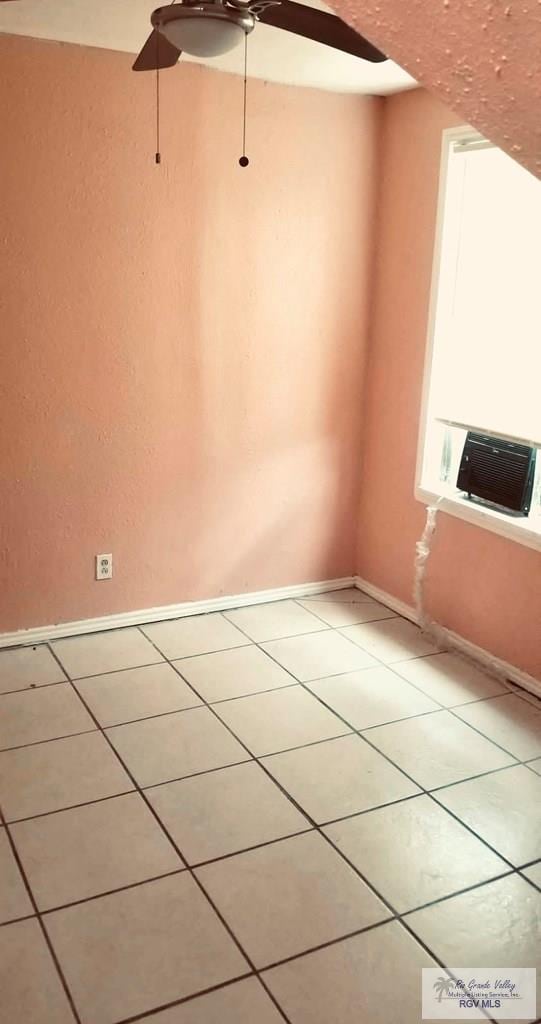 unfurnished room featuring light tile patterned flooring, ceiling fan, and baseboards