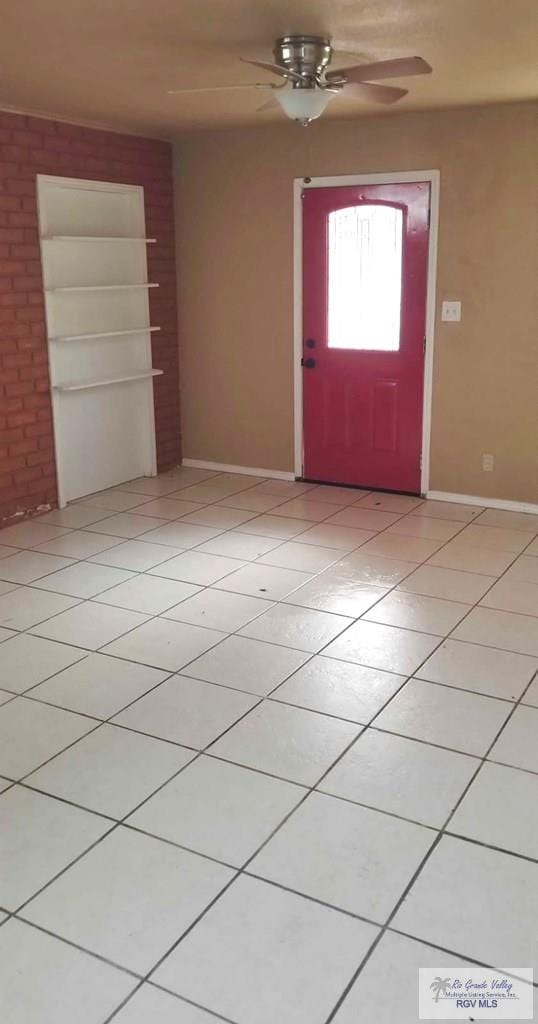 foyer entrance with light tile patterned flooring, ceiling fan, and baseboards