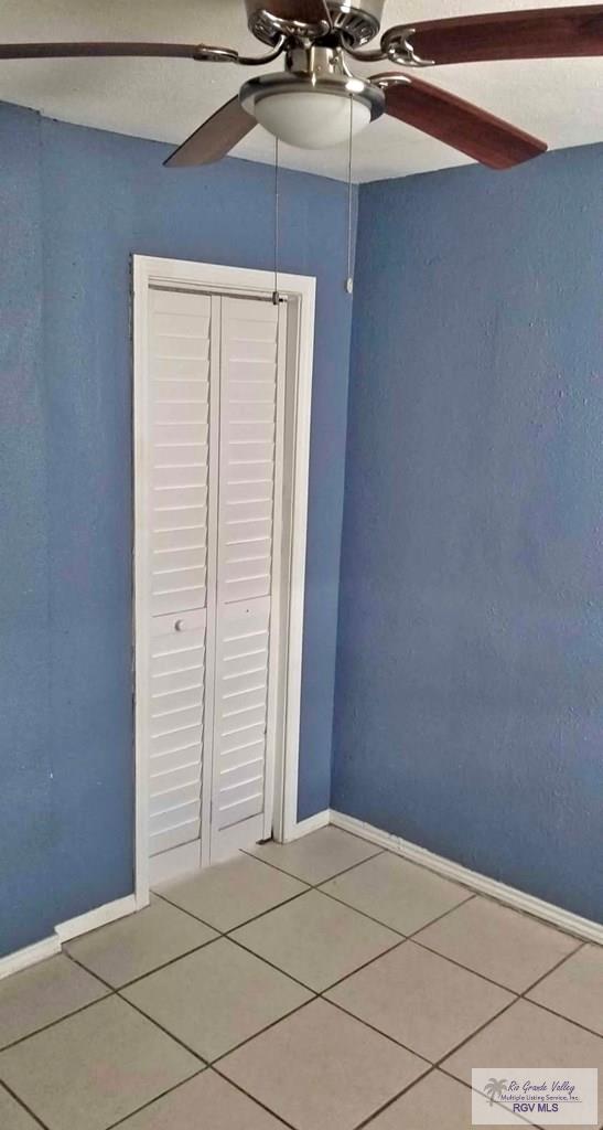 unfurnished bedroom featuring baseboards, a ceiling fan, and tile patterned floors