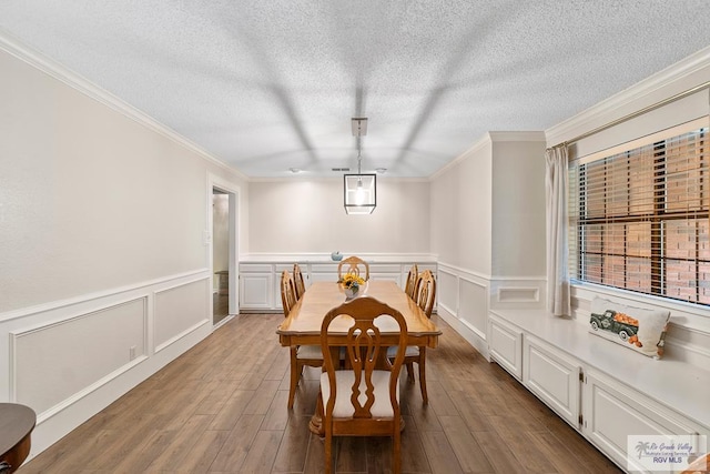 24382 Preston Trl, Harlingen, TX 78552 - dining area with crown molding, wood finished floors, a textured ceiling, wainscoting, and a decorative wall