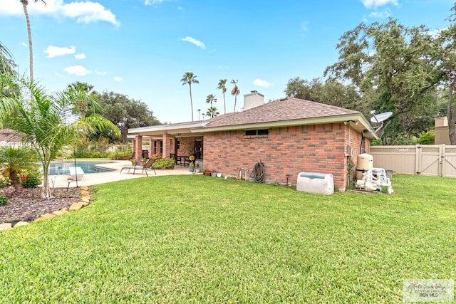 24382 Preston Trl, Harlingen, TX 78552 - rear view of property featuring a patio area, brick siding, a fenced backyard, a gate, and a chimney