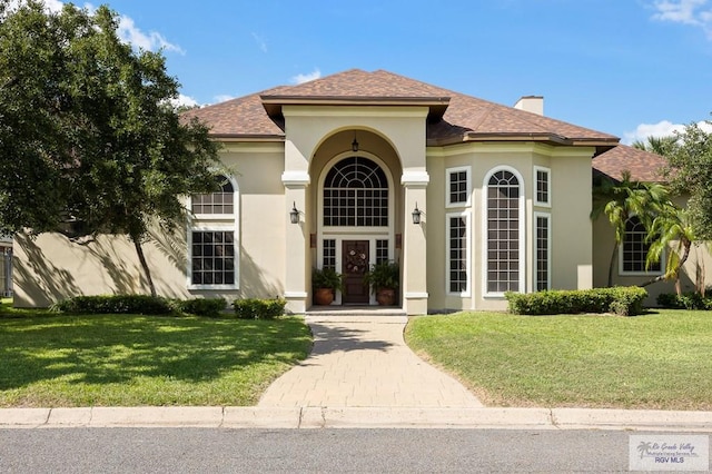 mediterranean / spanish-style house with a front yard