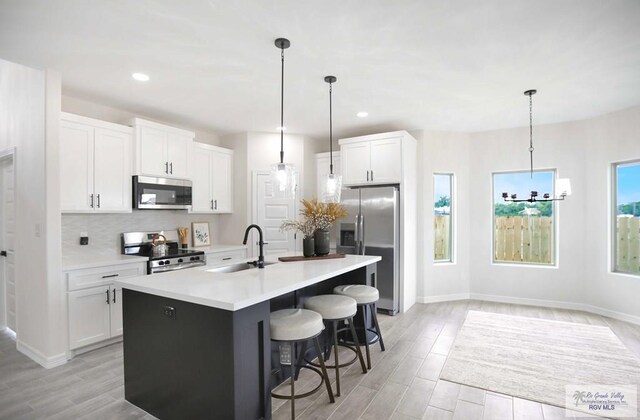 1838 Miley Ln, Harlingen, TX 78550 - kitchen featuring appliances with stainless steel finishes, white cabinetry, tasteful backsplash, and recessed lighting