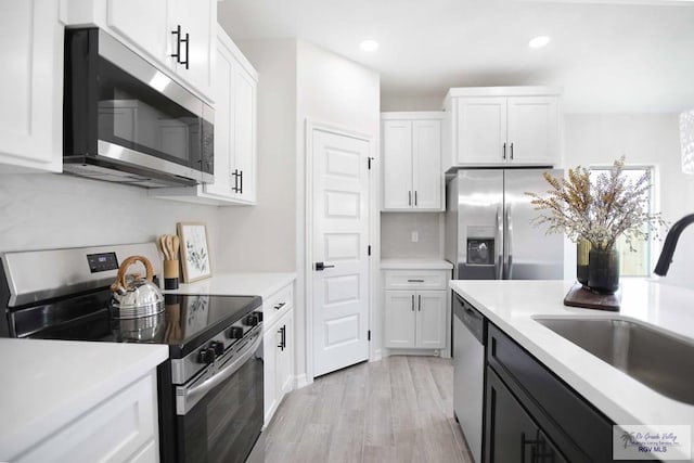 1838 Miley Ln, Harlingen, TX 78550 - kitchen featuring stainless steel appliances, white cabinetry, light countertops, light wood-type flooring, and recessed lighting