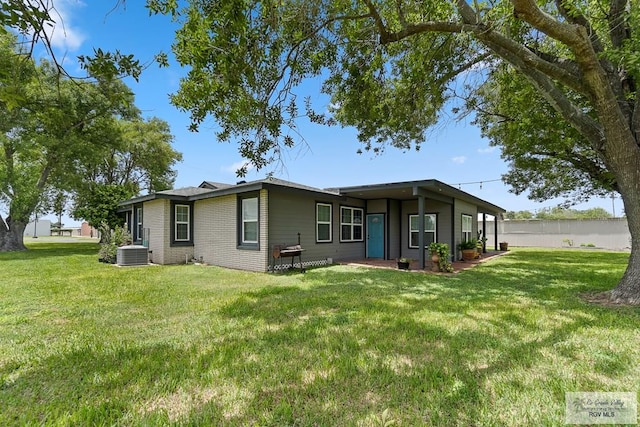 back of property with a yard and central air condition unit