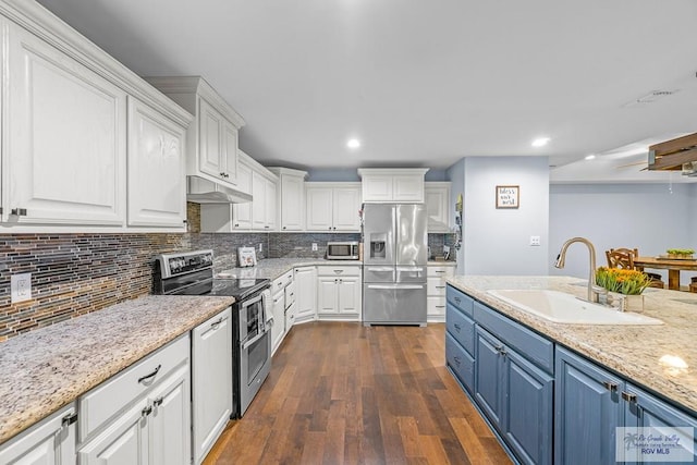 kitchen with blue cabinetry, stainless steel appliances, white cabinetry, and sink