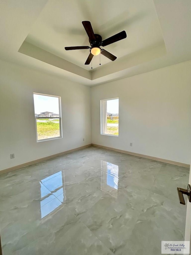 514 Oriole Dr, Los Fresnos, TX 78566 - empty room featuring a raised ceiling, concrete flooring, and a ceiling fan