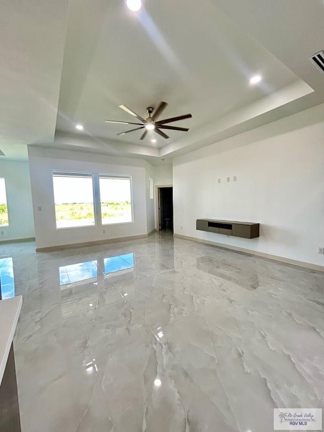 514 Oriole Dr, Los Fresnos, TX 78566 - unfurnished living room featuring a tray ceiling, ceiling fan, recessed lighting, and light marble finish floors