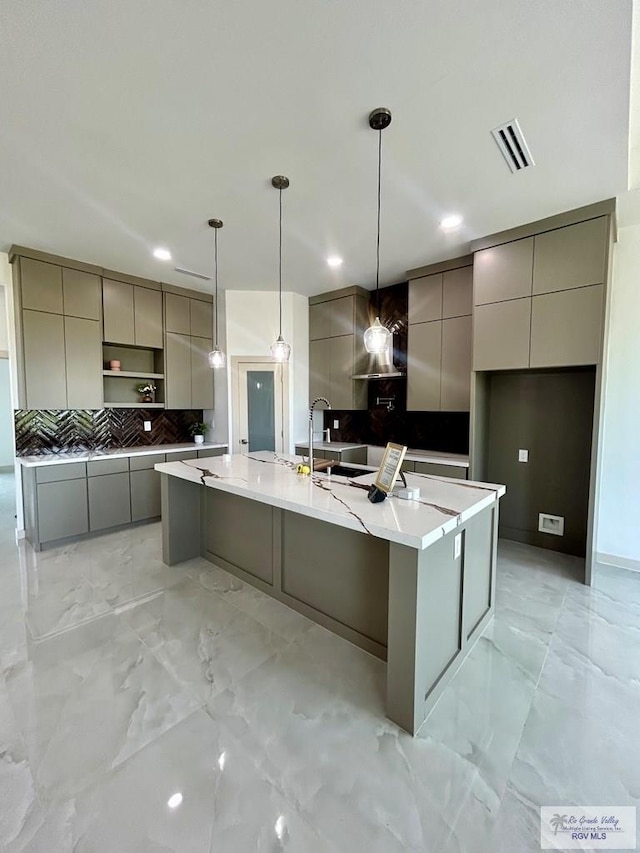 514 Oriole Dr, Los Fresnos, TX 78566 - kitchen with modern cabinets, gray cabinets, decorative backsplash, a spacious island, and light marble finish floors