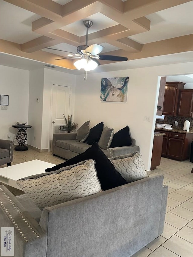 tiled living room with beam ceiling, coffered ceiling, and ceiling fan