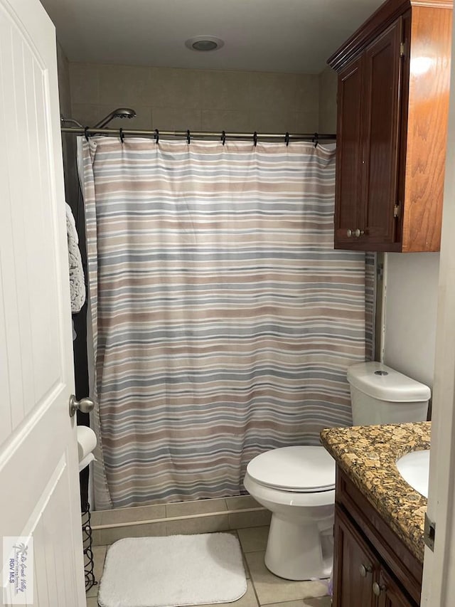 bathroom with vanity, toilet, curtained shower, and tile patterned flooring