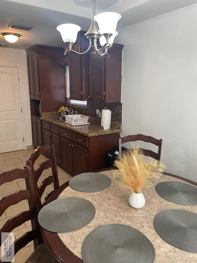 kitchen with tasteful backsplash, sink, dark brown cabinets, and light tile patterned floors