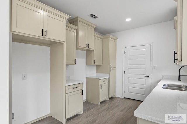 kitchen featuring cream cabinets, sink, and light hardwood / wood-style flooring