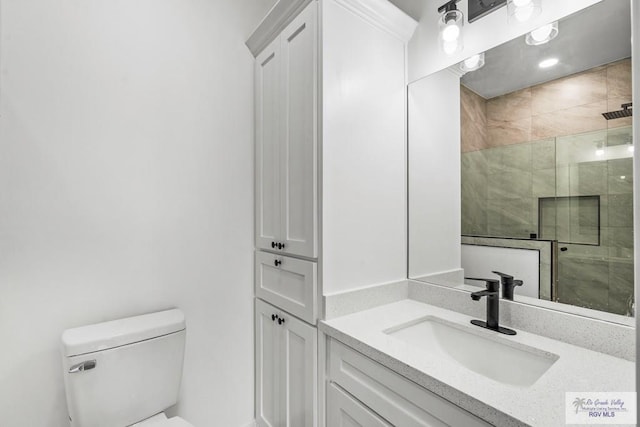 bathroom with a shower with door, vanity, and toilet