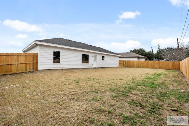 rear view of property featuring a lawn