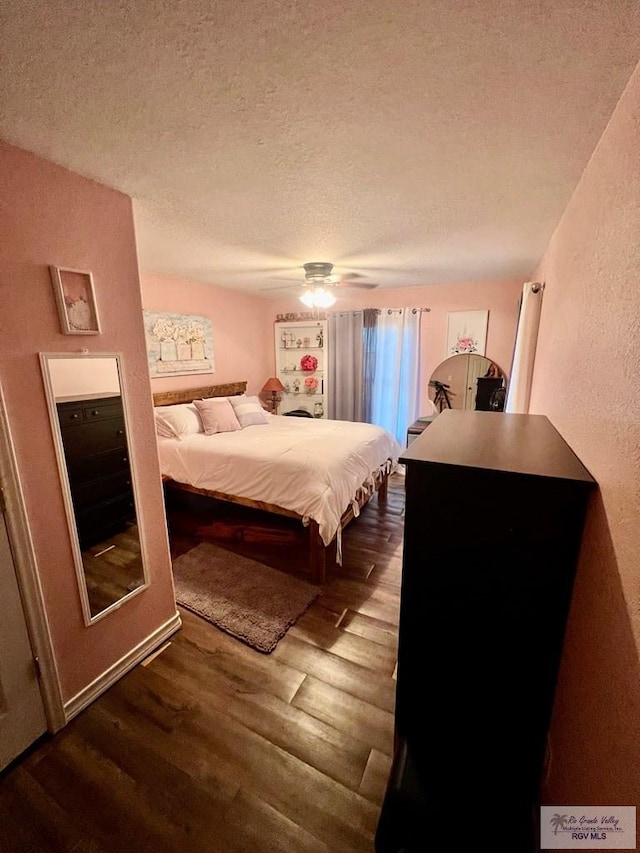 31360 Fm 1575, Los Fresnos, TX 78566 - bedroom with a textured ceiling, dark wood finished floors, a ceiling fan, and a textured wall